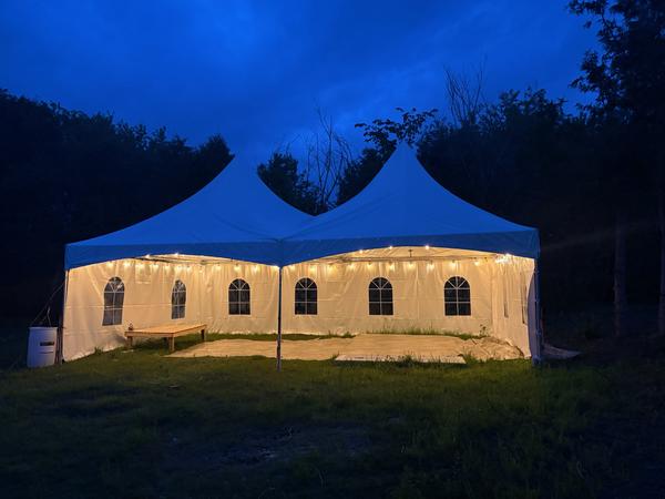 Wide twin-peak Skytop tent at dusk with lights on