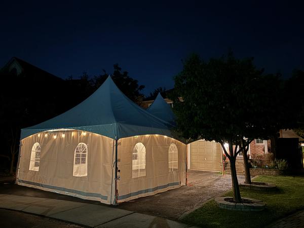 Skytop tent at night beside a garden tree